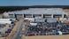 Tesla Gigafactory near Berlin with dozens of cars parked outside and grey concrete roof