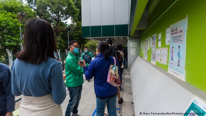 People queue outside a vaccination centre in Hong Kong