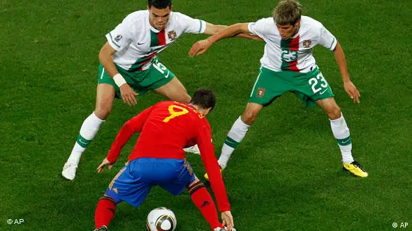 Spain's Fernando Torres, bottom, faces Portugal's Pepe, left, and Fabio Coentrao