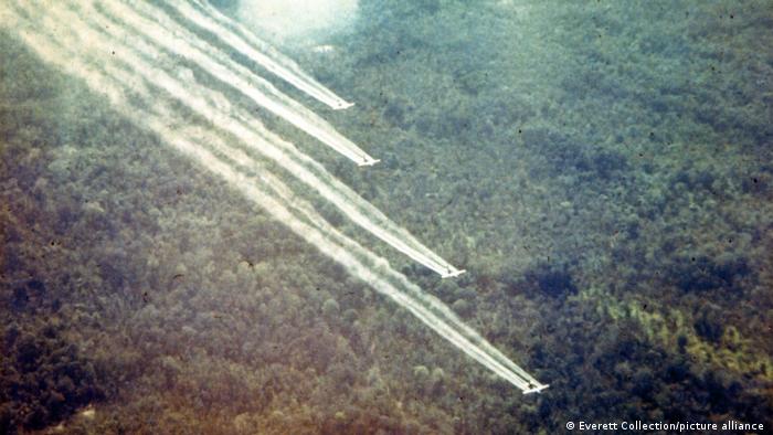 Four planes flying above forests spraying Agent Orange
