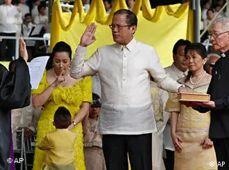 President Benigno Aquino III, center, takes his oath before Supreme Court Associated Justice Conchita Carpio-Morales as the Philippines' 15th President during inaugural ceremony Wednesday June 30, 2010 in Manila, Philippines. Aquino, the only son of Philippine democracy icons, the late President Corazon Aquino and assassinated opposition leader Sen. Benigno Aquino Jr., won by a landslide in the May 10 automated presidential elections. At right holding the Holy Bible is Jesuit priest Father Catalino Arevalo. (AP Photo/Bullit Marquez)