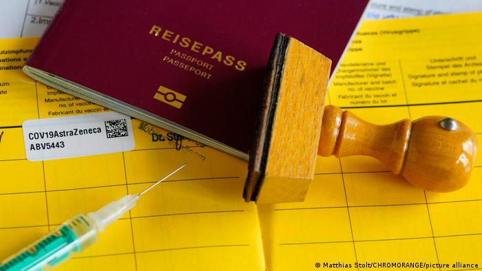 Deutscher gelber Impfpass mit der Eintragung COV19AstraZeneca und ein Reisepass