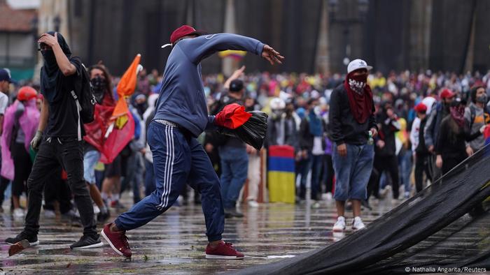 Un manifestante tira piedras a la policía en Colombia. Un manifestante tira piedras a la policía en Colombia.