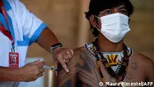 January 20, 2021 ***
(FILES) In this file photo taken on January 20, 2021 a Guarani indigenous man is inoculated with the Sinovac Biotech's CoronaVac vaccine against COVID-19 at the Sao Mata Verde Bonita tribe camp, in Guarani indigenous land, in the city of Marica, Rio de Janeiro state, Brazil, amid the new coronavirus pandemic. (Photo by Mauro Pimentel / AFP)