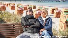Hardy und Sandra Eggert genießen die Sonne auf einer Bank am Strand. Nach der Entscheidung zu weiteren Öffnungsschritten in Tourismus und Gastronomie in Schleswig-Holstein bereitet sich die Region vor.