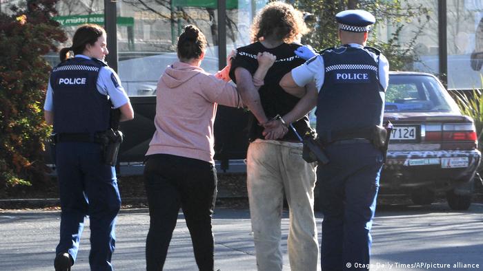Police take a suspect into custody near the Countdown supermarket in central Dunedin