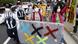 Masked protesters in Tokyo carry a modified Olympic logo Masked protesters in Tokyo carry a modified Olympic logo