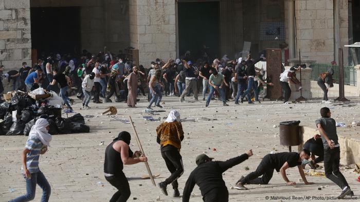 Palestinos em confronto com a polícia israelense em frente à mesquita Al Aqsa, em Jerusalém