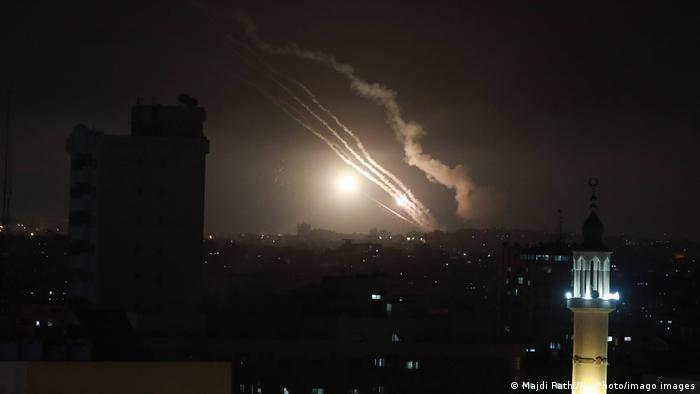 Дымовые следы от запущенных ракет в ночном небе над сектором Газа