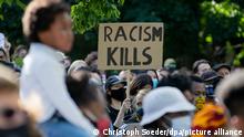 Ein Teilnehmer einer Kundgebung gegen den gewaltsamen Tod des Afroamerikaners George Floyd durch einen weißen Polizisten hält vor der US-Botschaft ein Plakat mit der Aufschrift „Racism kills“ (Rassismus tötet) hoch. Nach wochenlanger Corona-Einschränkung gibt es bei Demonstrationen in Berlin ab diesem Wochenende keine begrenzte Teilnehmerzahl mehr. Laut Polizei sind am heutigen Samstag (30.05.2020) mehrere Dutzend Demonstrationen angemeldet.