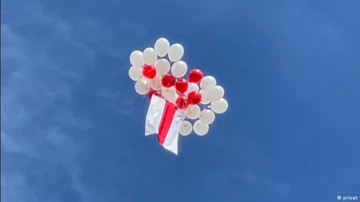 Бело-красно-белый флаг в небе, прикрепленный к белым и красным воздушным шарам