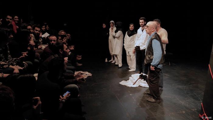 From a stage in Tehran, a man addresses the audience standing beside a group of transgender actors From a stage in Tehran, a man addresses the audience standing beside a group of transgender actors