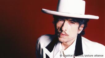 Bob Dylan wearing a white suit and white hat.