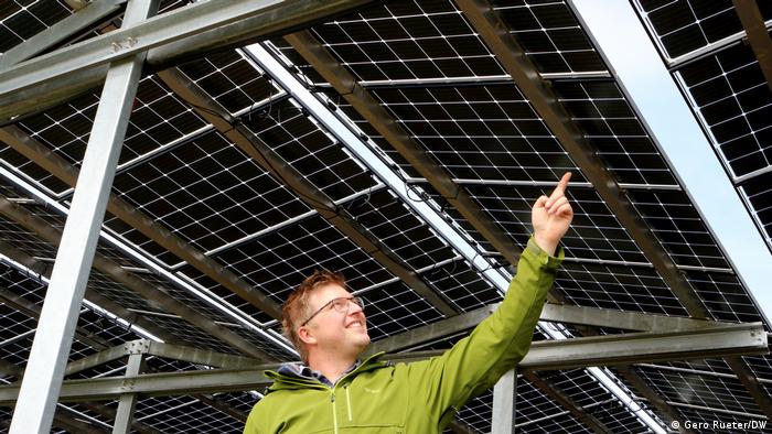 Agri-Photovoltaik: Fabian Karthaus, Landwirt und Photovoltaik Fan zeigt auf das PV-Dach.