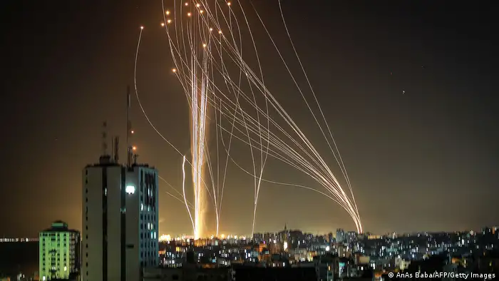 Dozens of rockets rise into the air in a long exposure that lets them be seen over Tel Aviv.
