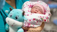 210214 -- BEIJING, Feb. 14, 2021 -- A baby born in the Year of the Ox is held by a health care worker at the maternity ward of Urumqi Maternal and Child Health Hospital in Urumqi, northwest China s Xinjiang Uygur Autonomous Region, Feb. 12, 2021. XINHUA PHOTOS OF THE DAY HuxHuhu PUBLICATIONxNOTxINxCHN