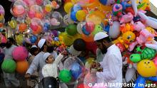 A child accompanying his parents buy baloons after offering special prayers on the occasion of Eid al-Fitr that marks the end of the holy month of Ramadan in Karachi on May 13, 2021. (Photo by Asif HASSAN / AFP) (Photo by ASIF HASSAN/AFP via Getty Images)