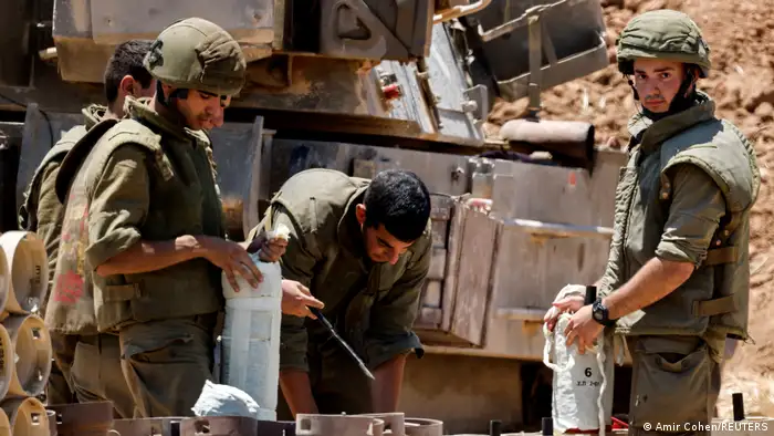 Israeli soldiers check artillery shells in an area near the border with Gaza