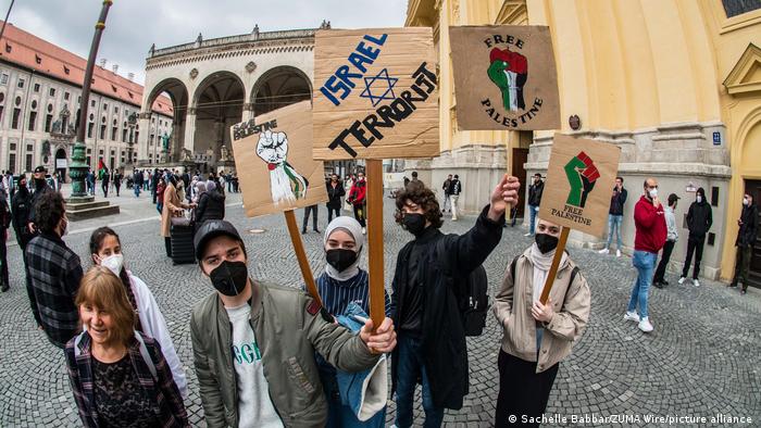 Junge Leute halten Protestschilder in die Höhe, um gegen Israels Besatzungspolitik zu demonstrieren