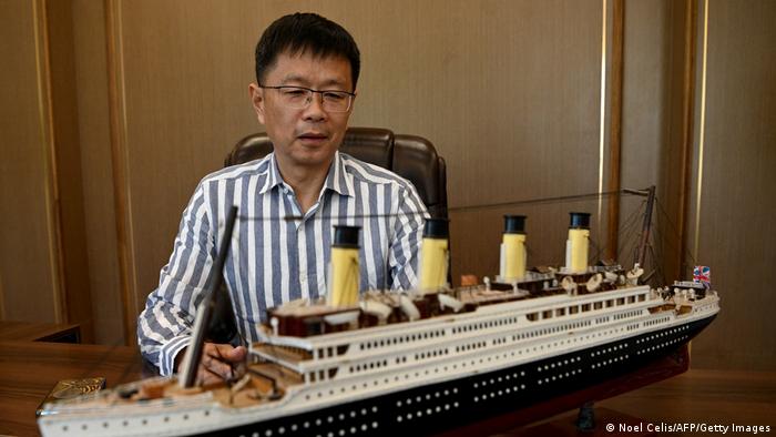 Su Shaojun holds a model of the Titanic.