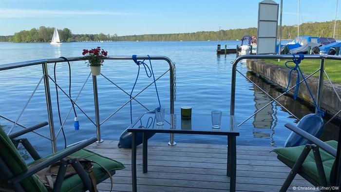 Houseboat rear deck with table and chairs looking out over a lake, Germany