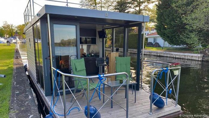 Germany, houseboat moored on a riverbank