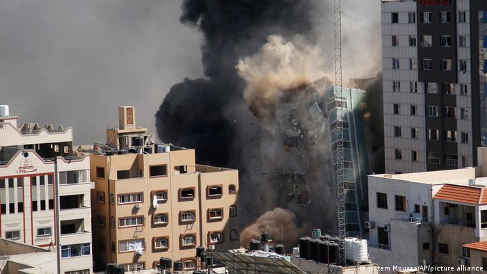 Smoke rises as a building falls after an Israeli airstrike in Gaza