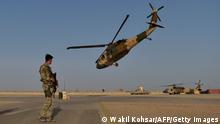 25.03.2021***In this photograph taken on March 25, 2021 an Afghan Commandos (ANA) soldier stands guard as an Afghan Air Force Black Hawk helicopter takes off at the Shorab Military Camp in Lashkar Gah, in the Afghan province of Helmand. (Photo by WAKIL KOHSAR / AFP) (Photo by WAKIL KOHSAR/AFP via Getty Images)