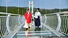 Models dressed in Hanfu or traditional Chinese costume pose on a glass-bottomed bridge in Foshan city, south China's Guangdong province, 30 January 2019. People wearing Hanfu, Chinese traditional costume, walk during an event on a glass-bottomed bridge in Foshan city, south China's Guangdong province, 30 January 2019. More than 100 Hanfu lovers attended the event to promote traditional Chinese culture.
