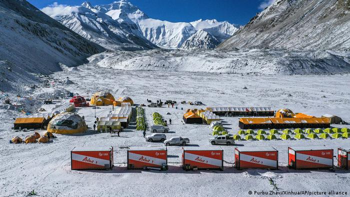 Foto aérea de archivo: vehículos y tiendas de campaña en el campamento base al pie del lado chino de la cima del monte Qomolangma, también conocido como monte Everest, en la región autónoma del Tíbet, al suroeste de China.