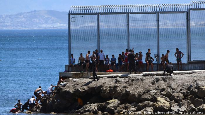  Spanish Guardia Civil officers try to stop people from Morocco entering into the Spanish territory at the border of Morocco and Spain, at the Spanish enclave of Ceuta