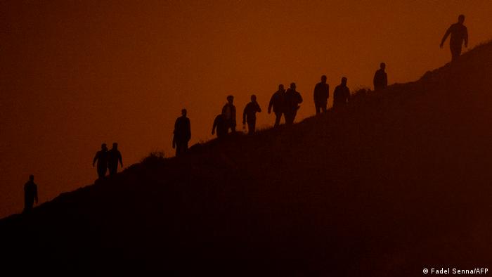 Moroccan migrants climb on cliffs in Fnideq, Morocco.