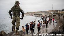 People mainly from Morocco stand on the shore as Spanish Army cordon off the area at the border of Morocco and Spain, at the Spanish enclave of Ceuta, on Tuesday, May 18, 2021. Ceuta, a Spanish city of 85,000 in northern Africa, faces a humanitarian crisis after thousands of Moroccans took advantage of relaxed border control in their country to swim or paddle in inflatable boats into European soil. Around 6,000 people had crossed by Tuesday morning since the first arrivals began in the early hours of Monday, including 1,500 who are presumed to be teenagers. (AP Photo/Javier Fergo)