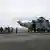 People who were stranded at sea due to Cyclone Tauktae exit an Indian Navy chopper. 