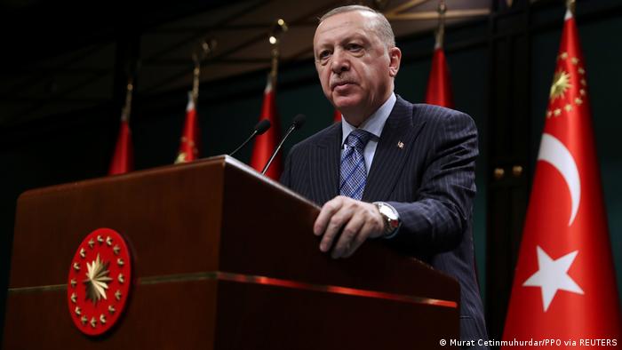 Turkish President Recep Tayyip Erdogan stands behind lectern