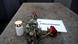 A candle, roses and a note reading #weremember - commemorating the liberation of Auschwitz A candle, roses and a note reading #weremember - commemorating the liberation of Auschwitz