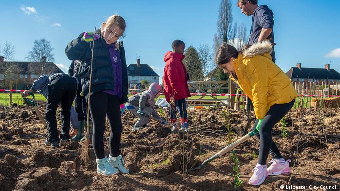 Kinder graben und pflanzen an einem Frühlingstag in Leicester, Großbritannien