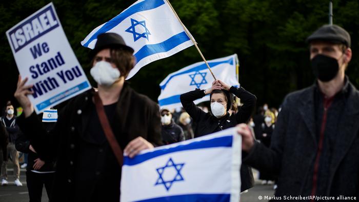 People with Israeli flags attend a rally in Berlin in support of Israel