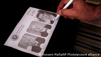 Cédula eleitoral síria com três fotografias dos candidatos 