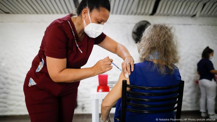 An older woman is vaccinated against the coronavirus in Argentina