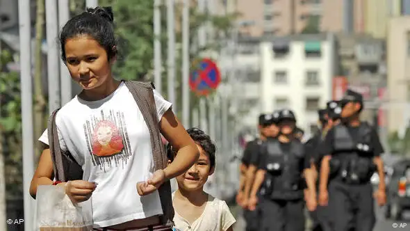 China Xinjiang Frau und Kind vor Polizeitruppe