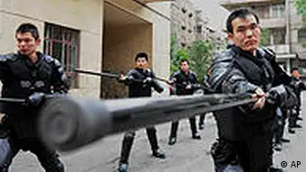 In this Saturday, July 3, 2010 photo, policemen take part in a daily training at a police station in Urumqi, in northwest China's Xinjiang region. Teams of police patrolled streets in the western region of Xinjiang on Monday as stringent security was imposed for the one-year anniversary of China's worst ethnic violence in decades. (AP Photo) ** CHINA OUT **