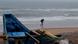 A man walks holding an umbrella during a drizzle at the Puri beach on the Bay of Bengalcoast in Odisha, India A man walks holding an umbrella during a drizzle at the Puri beach on the Bay of Bengalcoast in Odisha, India