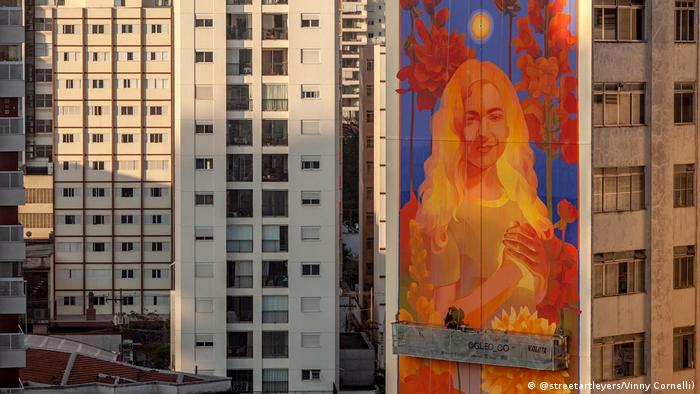 Mural de la artista Gleo en Sao Paulo, Brasil: una mujer con las manos sobre el corazón.