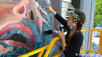Mariela Ajras, muralista argentina, en plena tarea.