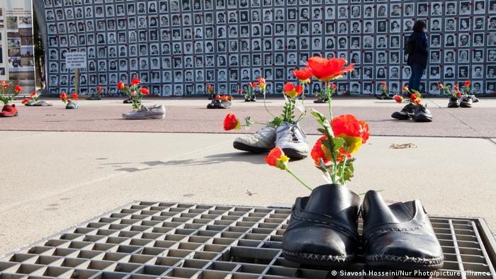Shoes, photos and flowers are displayed in front of the UN headquarters in Geneva
