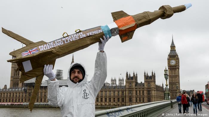 An Amnesty International activist holds a homemade replica missile bearing the message 'Made in Britain, destroying lives in Yemen'