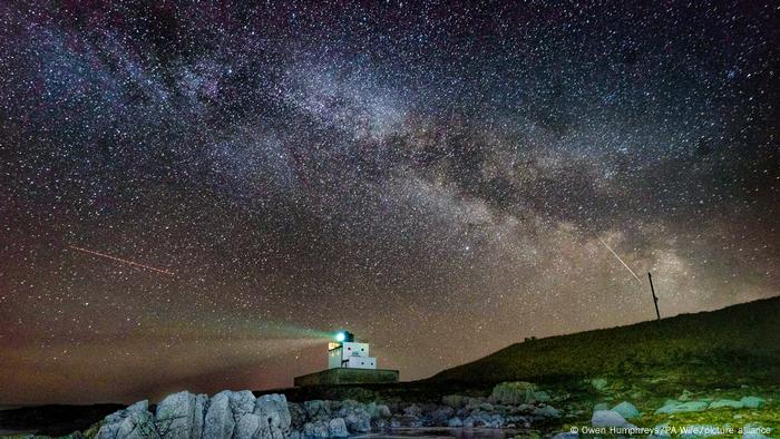  El núcleo de la Vía Láctea se hace visible en las primeras horas de la mañana del martes mientras se desplaza sobre el faro de Bamburgh, en Stag Rock, en Northumberland, Reino Unido.