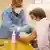 Медработник прививает пациента от коронавируса в Германии