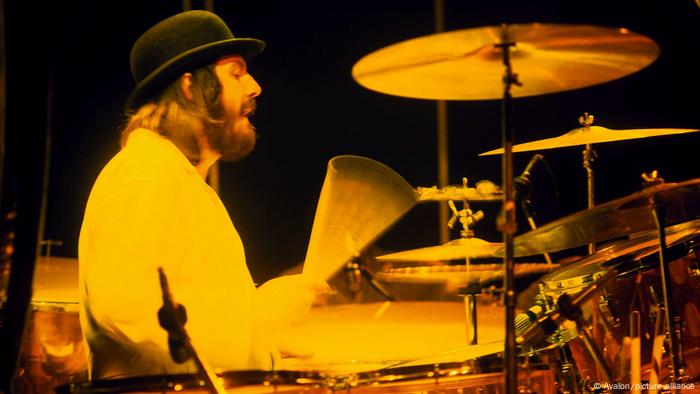 John Bonham wearing a bowler hat while playing the drums. 